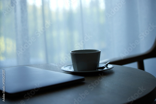 テーブルに置かれたコーヒーとノートパソコン