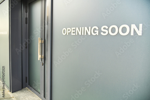 Opening Soon sign on gray obscured shop window