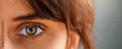 Close up of tired young woman eyes. Blurred vision, burst blood vassels, and eye strain concept. Concept of yey health, strain,andtreatment.