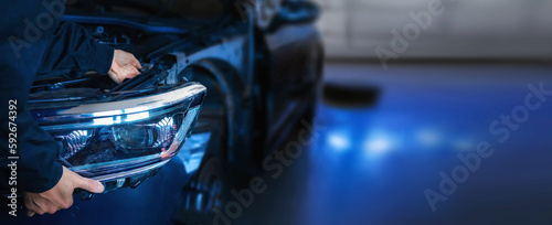 Fotografie, Tablou Mechanic changing car headlight in a workshop