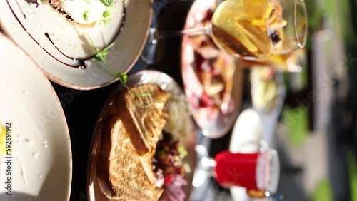 Served table with food and drinks. Restaurant on terrace. Camera moving. Vertical video