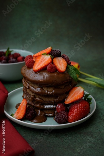 Closeup view of chocolate pancakes decorated with berries