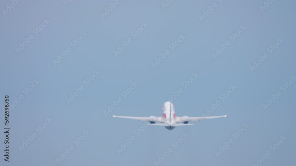 Rear view of a jet passenger plane take off, departure. Runway, airfield, airport. Unrecognizable airliner flies away. View through the airport fence