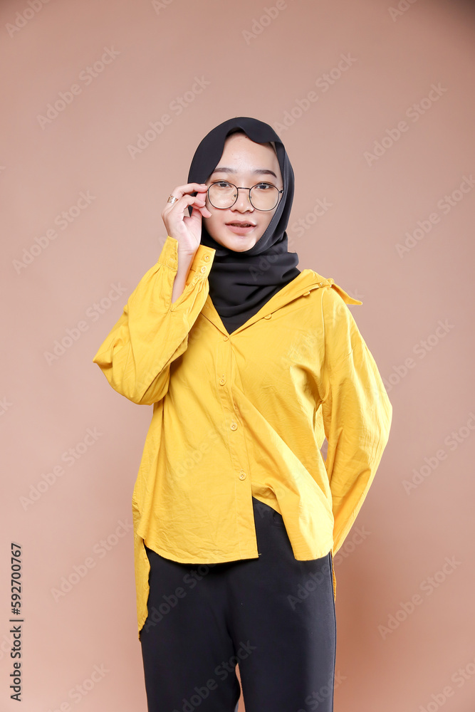 Cute young Asian hijab corporate girl with smooth glowing skin smiling and relaxing over an isolated background studio. Beauty skin care, office concept. Cute young Asian hijab corporate girl with smooth glowing skin smiling and relaxing over an isolated background studio. Beauty skin care, office concept.