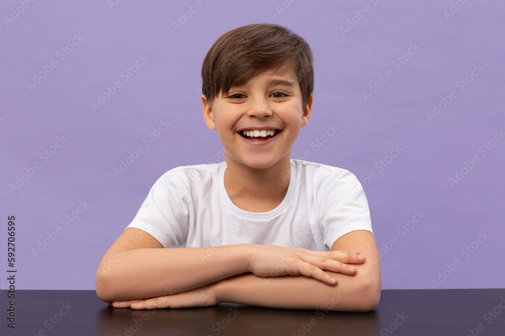Happy schoolboys sitting at desk, classroom. Violet background Happy schoolboys sitting at desk, classroom. Violet background