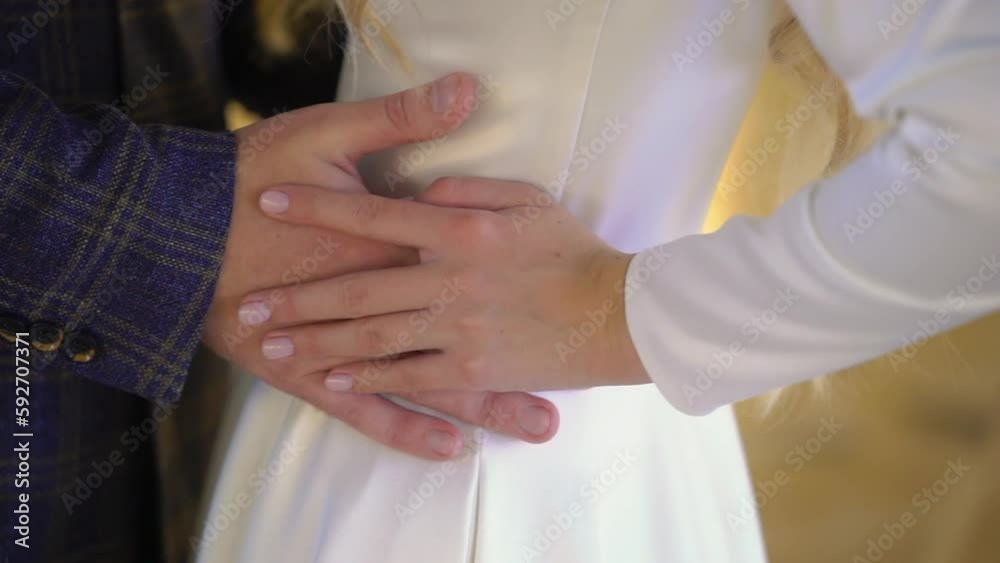 The bride and groom are hugging. A young couple in love in a white wedding dress and a blue classic suit. Husband and wife - relationship, family, wedding anniversary or honeymoon. The bride and groom are hugging. A young couple in love in a white wedding dress and a blue classic suit. Husband and wife - relationship, family, wedding anniversary or honeymoon.