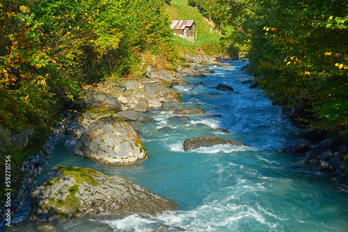 Wallpaper Mural Mountain river with a wooden barn on the bank in the morning near the village of Lauterbrunnen in Switzerland. Torontodigital.ca