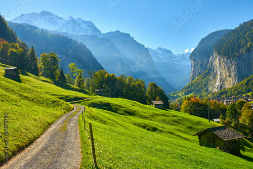 Mountain morning view with old wooden barns near the road in Lauterbrunnen valley in Switzerland.