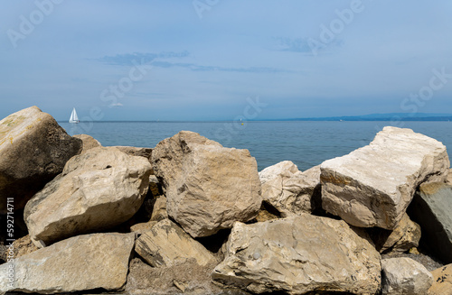 View of the Adriatic Sea and sailboats from the embankment through large stones