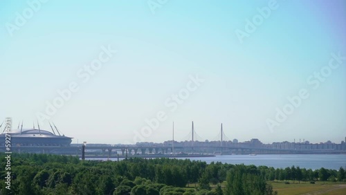 Urban landscape. View of the river, blue water, embankment. Modern cable-stayed highway bridge. Stadium building and summer park. Saint-Petersburg, Russia. Zenith arena and zsd. photo