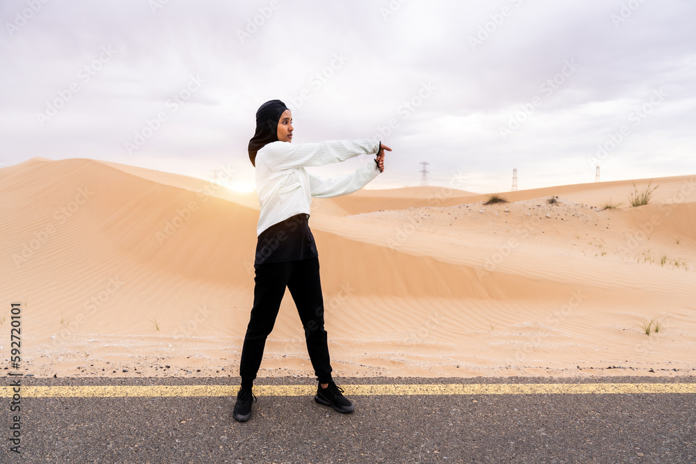 Beautiful middle-eastern arab woman wearing hijab training outdoors in a desert area - Sportive athletic muslim adult female wearing burkini sportswear doing fitness workout Beautiful middle-eastern arab woman wearing hijab training outdoors in a desert area - Sportive athletic muslim adult female wearing burkini sportswear doing fitness workout