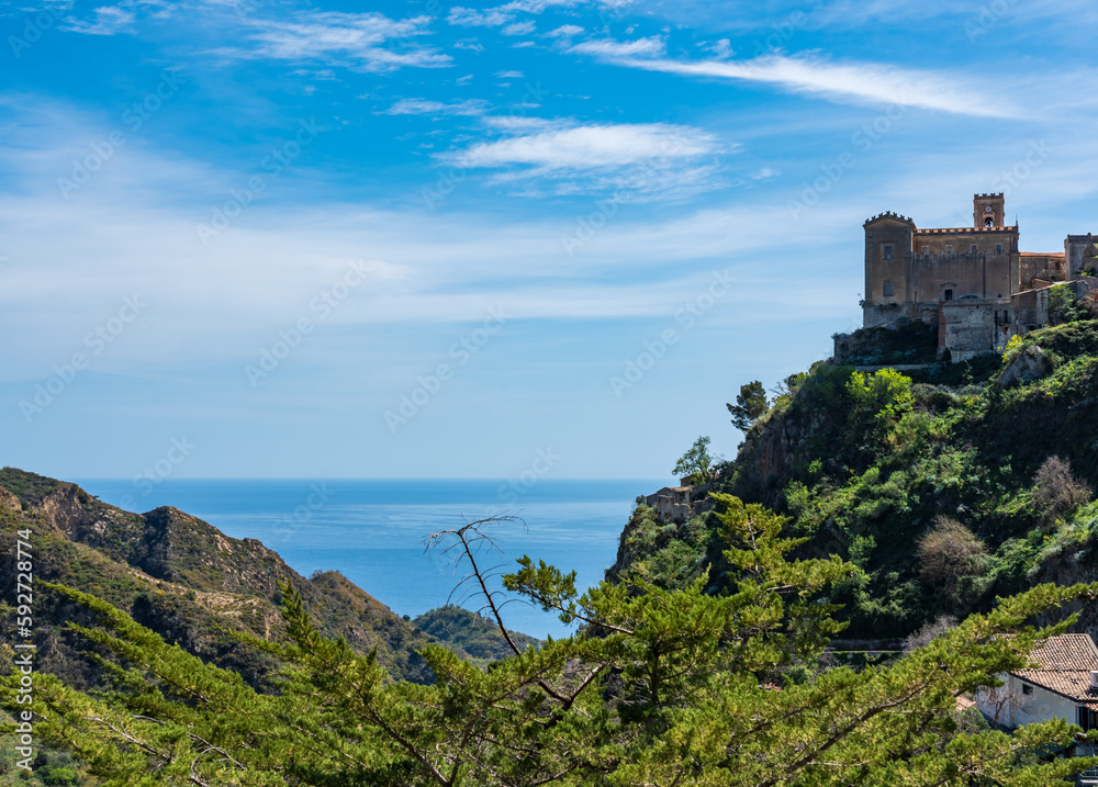 panorama of the Ionian Sea seen from the heights of Savoca, a town in western Sicily, with an ancient castle to the right, on a clear sunny day