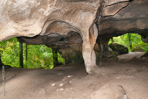 Huel Lee or Hohllay on the Mullerthal trail in Luxembourg, open cave with view to the forest, sandstone rock formation
