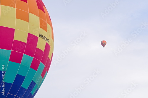 Balão de ar quente colorido voando pelo céu azul photo