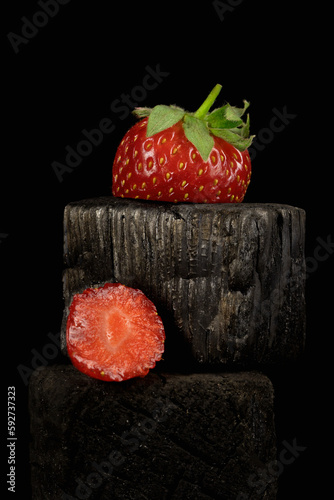 Ripe strawberries cut on a black background.