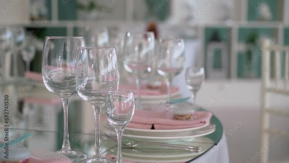 Served tables for a holiday in a restaurant. Glasses, plates, cutlery, napkins. Wedding decor, celebration dinner or party, reception indoors. No food. Served tables for a holiday in a restaurant. Glasses, plates, cutlery, napkins. Wedding decor, celebration dinner or party, reception indoors. No food.