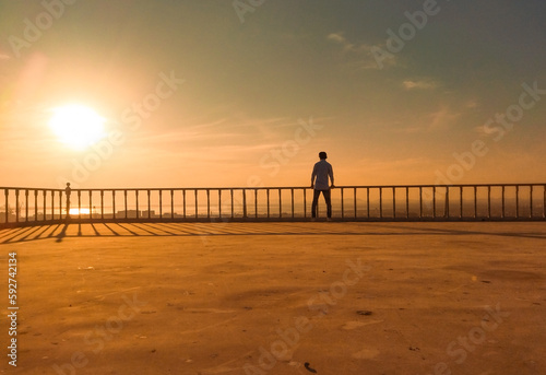 Sun-Kissed Perspective: Boy's Skyward Gaze from the Roof