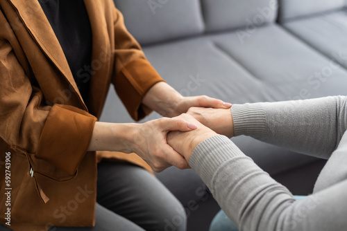 Closeup of a support hands. Closeup shot of a young woman holding a senior woman's hands in comfort. Female carer holding hands of senior woman © Angelov