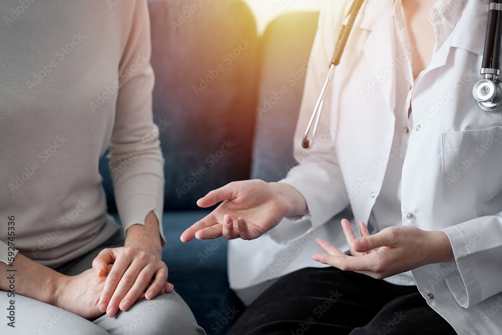 Doctor and patient discussing current health examination while sitting at sofa in clinic office, closeup. Medicine concept Doctor and patient discussing current health examination while sitting at sofa in clinic office, closeup. Medicine concept