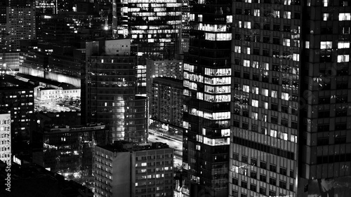 View of at night glass buildings and modern business skyscrapers,. View of modern skyscrapers and business buildings in downtown. Big city at night. Black and white.