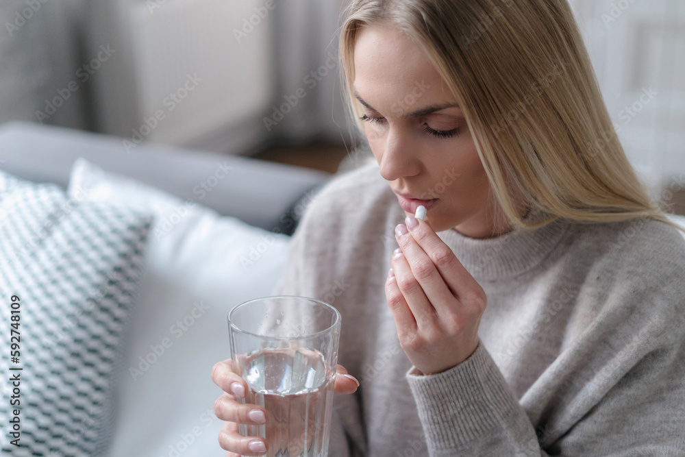 woman feeling sick and taking prescription pills woman feeling sick and taking prescription pills