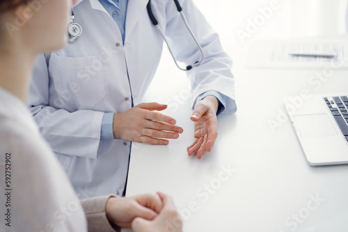 Doctor and patient discussing current health questions while sitting at the table in clinic office  only hands closeup. Medicine concept