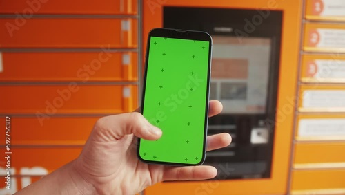 Wallpaper Mural Hand holding smartphone with green screen on public gas petrol station background, road payment system with phone app Torontodigital.ca