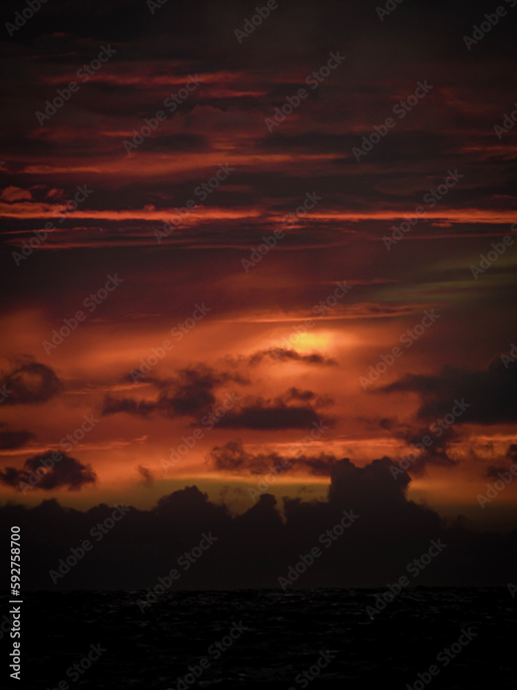 Fototapeta premium sunrise with dramatic clouds on the beach