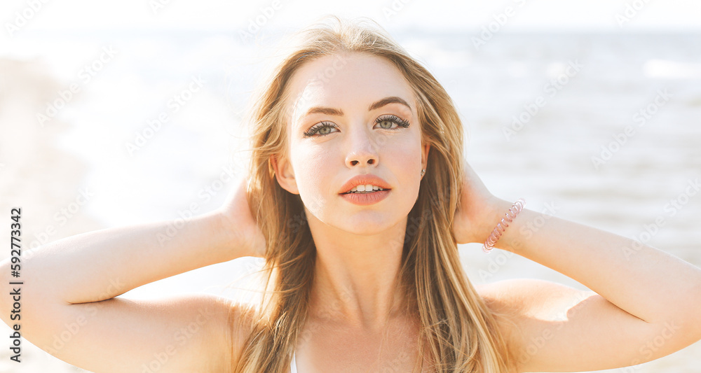 Happy blonde woman in free happiness bliss on ocean beach standing straight and posing Happy blonde woman in free happiness bliss on ocean beach standing straight and posing