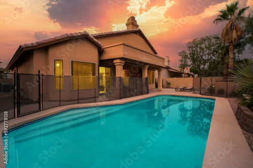 a luxury pool at sunset with a gazebo 