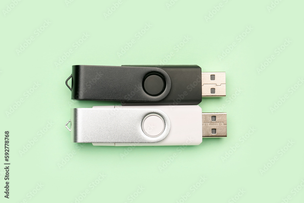 Black and white USB flash drives on green background Black and white USB flash drives on green background