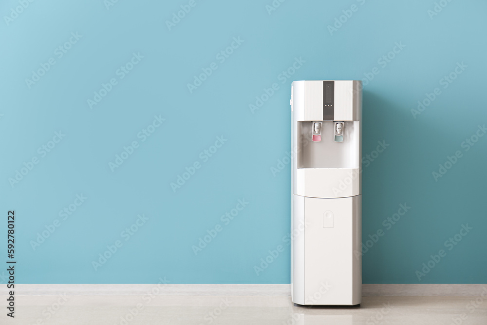Modern water cooler near blue wall Modern water cooler near blue wall
