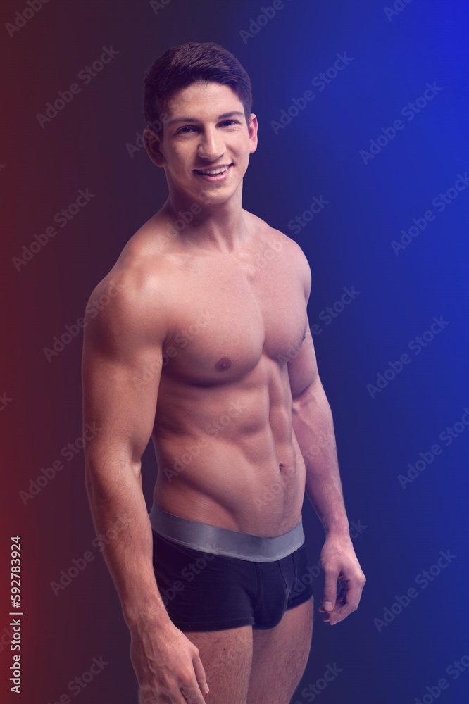 Fototapeta premium Young muscled man posing is studio.