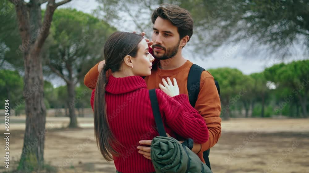 Happy lovers standing forest with backpacks close up. Tender travelers hugging. Happy lovers standing forest with backpacks close up. Tender travelers hugging.