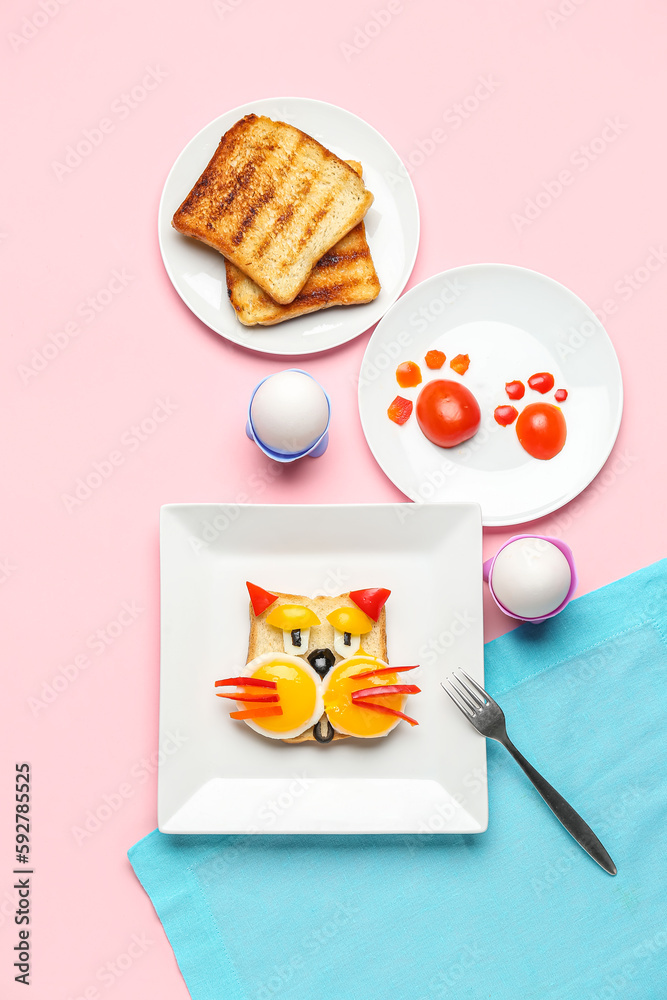 Plate with funny breakfast in shape of cat, toasts and vegetables on pink background