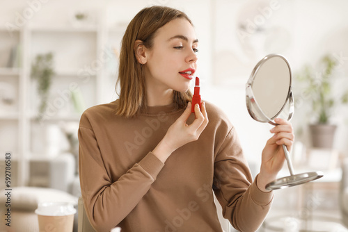 Young woman applying red li...