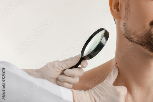 Dermatologist examining mol...