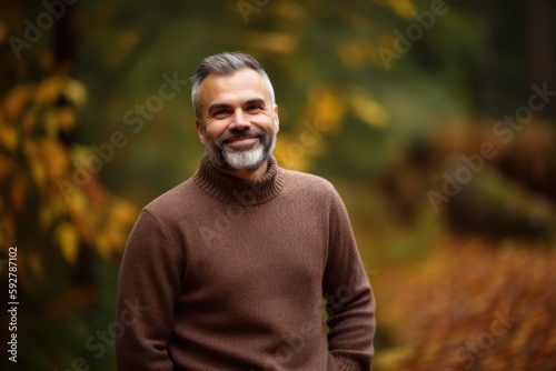 Portrait of a handsome mature man in an autumn park. Smiling man.
