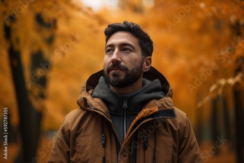 Portrait of a handsome bearded man in a brown jacket on an autumn background. © Robert MEYNER