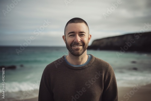 Portrait of a handsome young man smiling at the camera on the beach