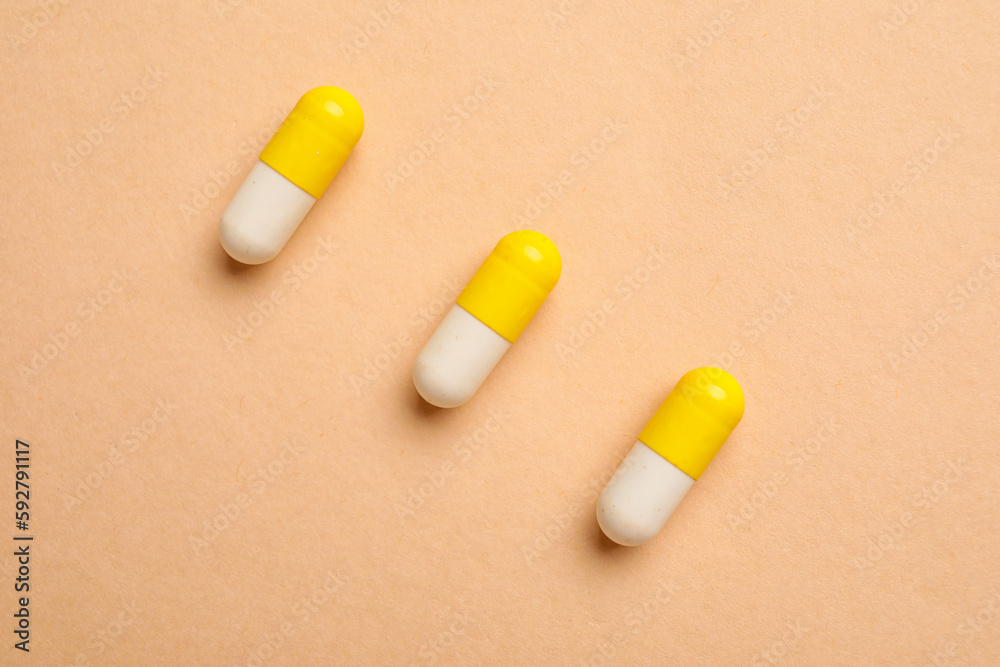 Capsules on beige background, top view Capsules on beige background, top view