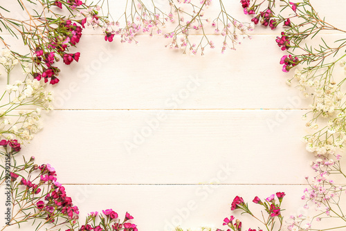 Frame made of gypsophila flowers on white wooden background © Pixel-Shot