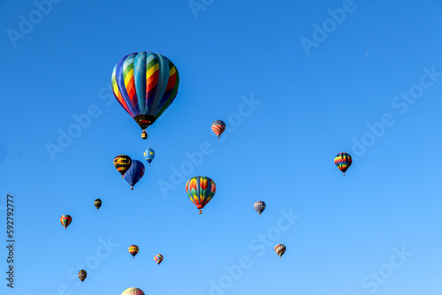 14 colorful hot air balloons in flight against the bright blue sky on a crisp October day at the Albuquerque International Balloon Fiesta New Mexico. People come from all over the world.