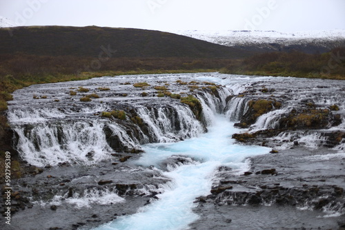 In the photo  the famous  magnificent and incredibly beautiful Icelandic cascade waterfall Bruarfoss with laser blue glacial water