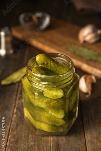 Jar with tasty fermented cucumbers on wooden table