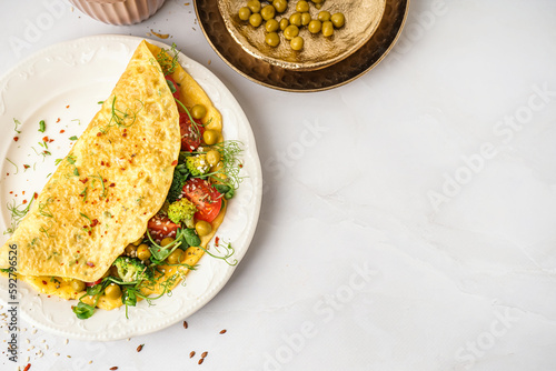 Tasty omelet with vegetables on light background