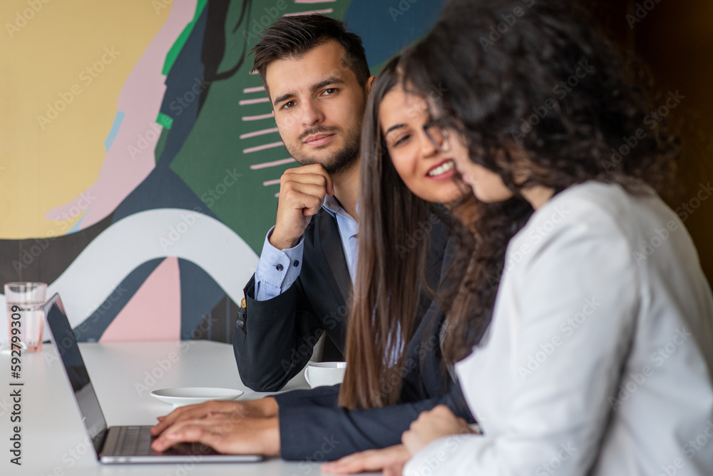 Business team collaborating on project together, using laptops. Business colleagues in casual working together in contemporary office space. Business team collaborating on project together, using laptops. Business colleagues in casual working together in contemporary office space.