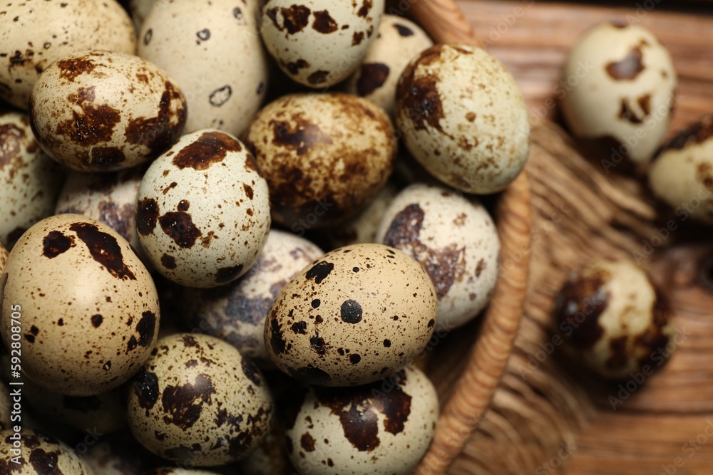 Wooden bowl with quail eggs on table, closeup Wooden bowl with quail eggs on table, closeup