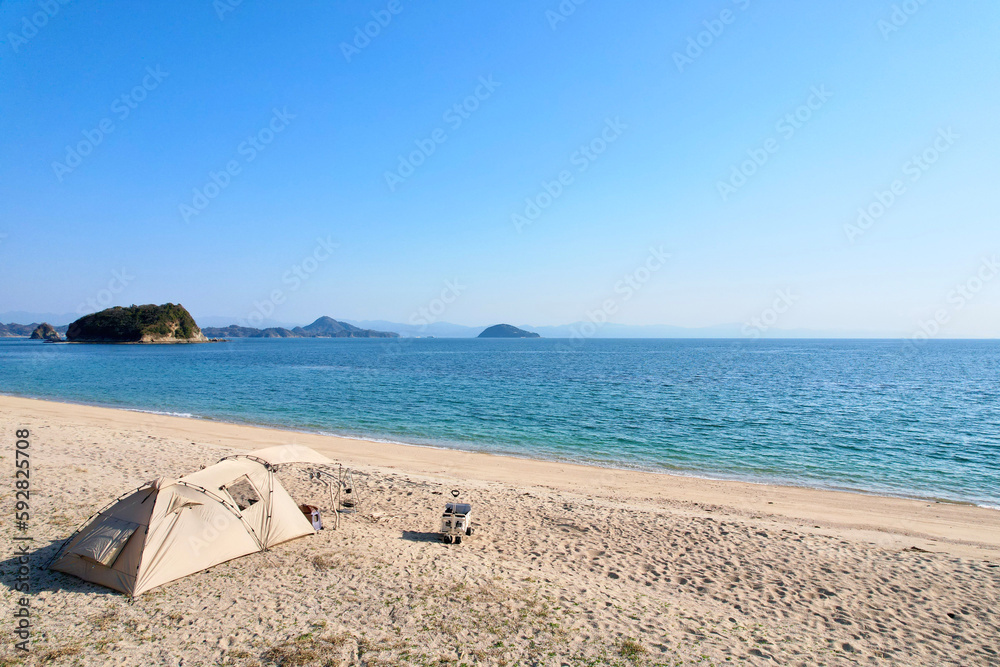 トイプードルを連れて女子キャンプ　青い海・美しいビーチでのんびり島キャンプ　キャンプ料理や愛犬と休日を楽しむ女性　海の見えるキャンプ
