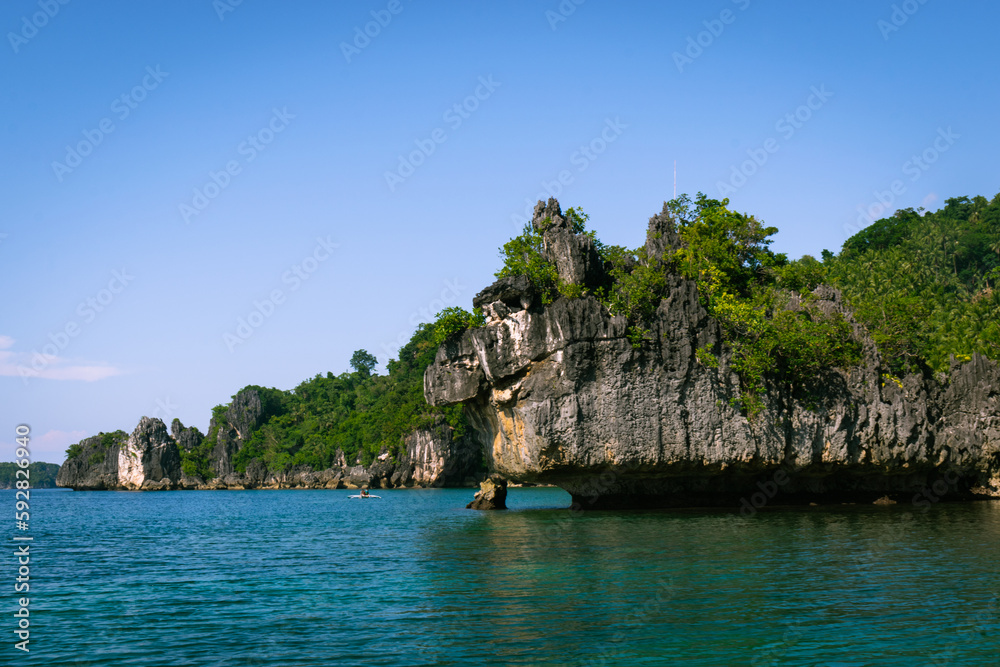 Tropical island rocks on a blue sea. Calatrava, Romblon, Philippines